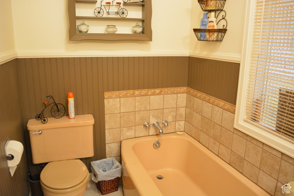 Full bathroom with a bath and a wainscoted wall