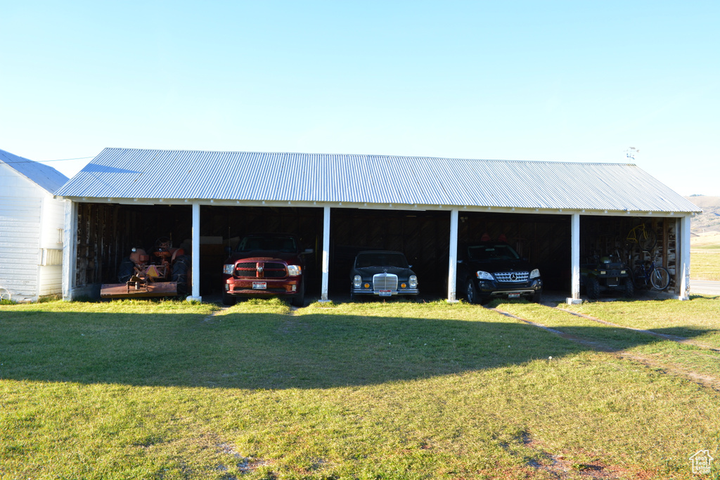 View of pole building with a detached carport and a yard