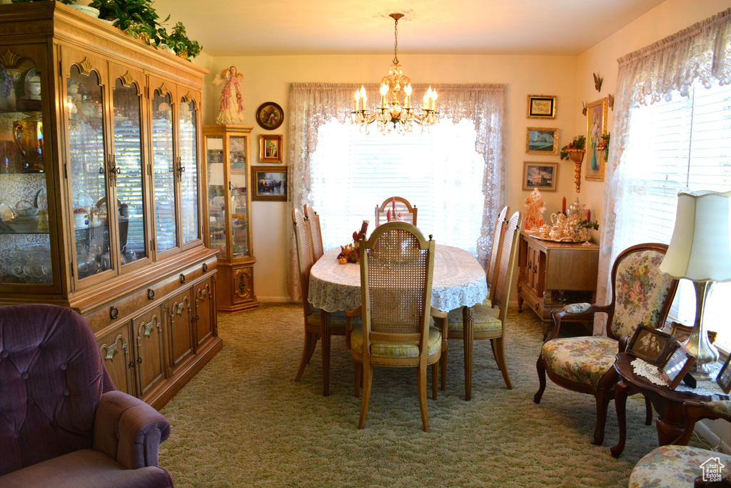 Carpeted dining room with a chandelier and plenty of natural light