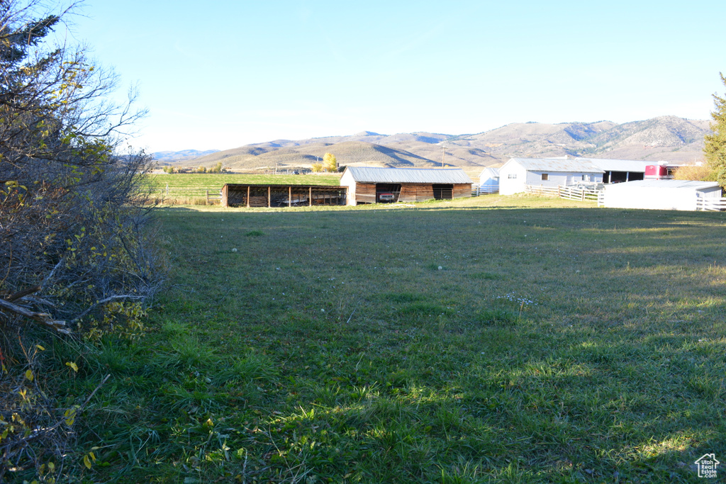View of yard with a mountain view, a view of rural / pastoral area, an outbuilding, and a pole building