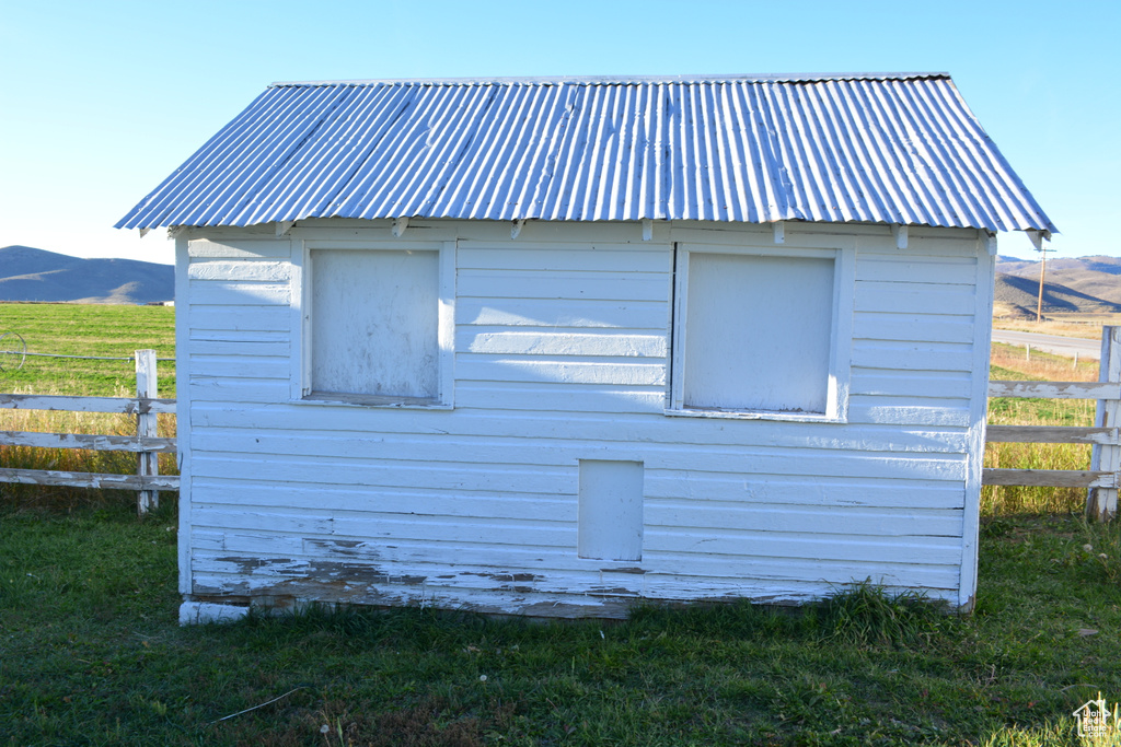 View of side of property with a metal roof, an outdoor structure, and a mountain view