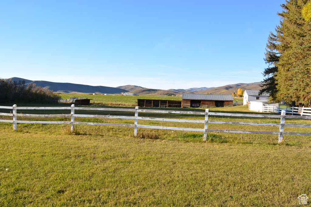 View of yard with a view of rural / pastoral area, a mountain view, an outdoor structure, and an outbuilding