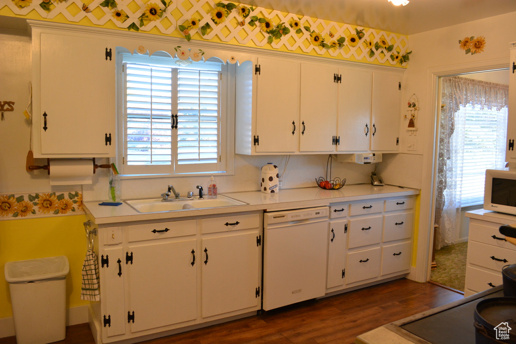 Kitchen with dishwasher, white cabinetry, dark wood-style flooring, and light countertops