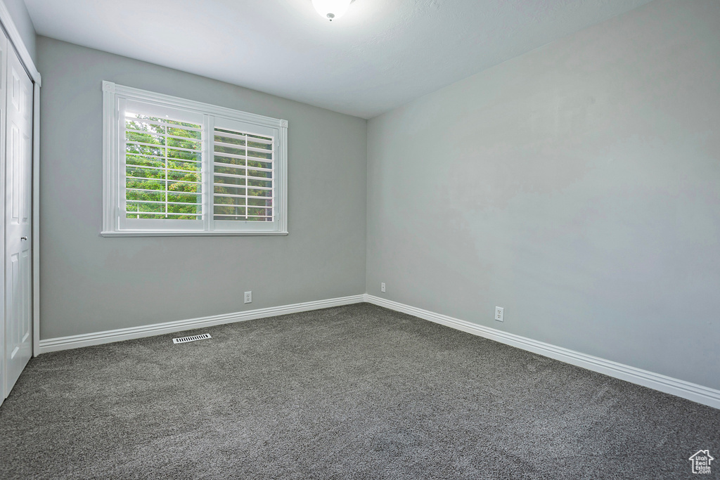 Unfurnished bedroom with carpet flooring and baseboards
