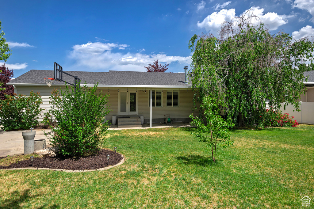 View of front of home featuring french doors, a front lawn, and roof with shingles