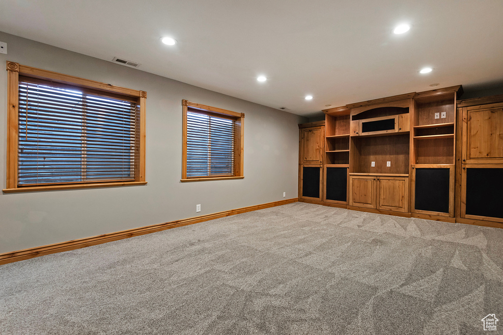 Unfurnished living room with light colored carpet and recessed lighting