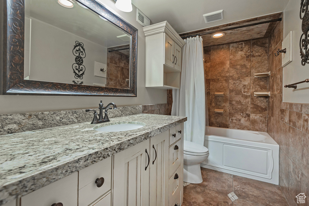 Bathroom featuring vanity, shower / bath combo, and tile patterned flooring