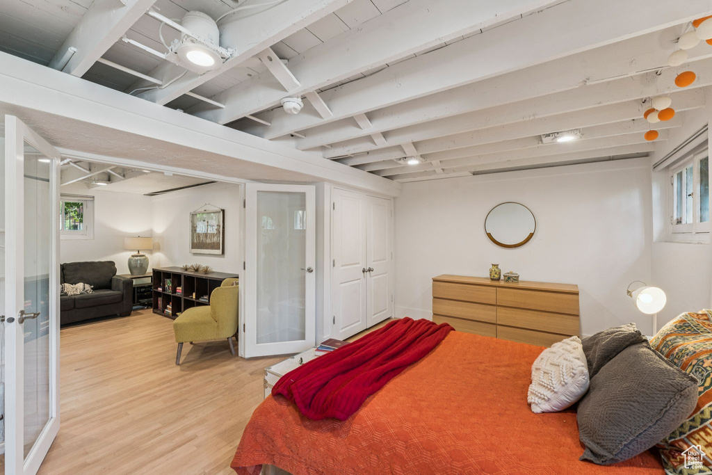 Bedroom featuring light wood-style flooring, multiple windows, and french doors