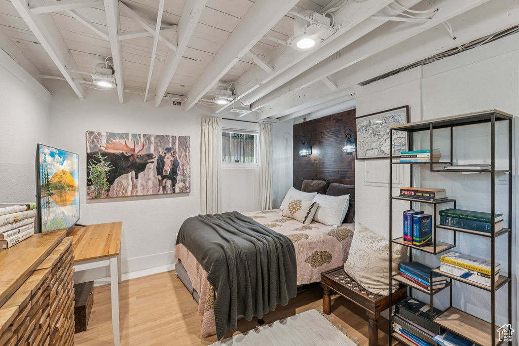 Bedroom featuring wood finished floors and beam ceiling