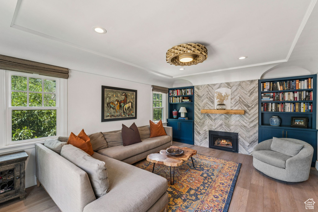 Living room with healthy amount of natural light, a tiled fireplace, wood finished floors, and recessed lighting
