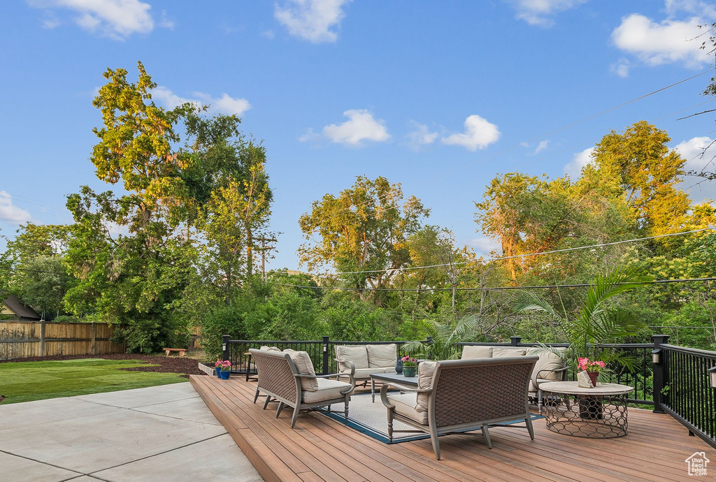 Wooden terrace with an outdoor hangout area and a fenced backyard
