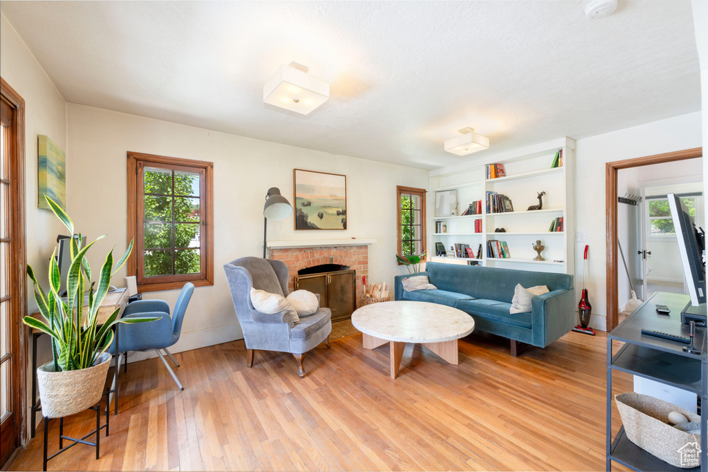 Living area with light wood-style flooring and a brick fireplace