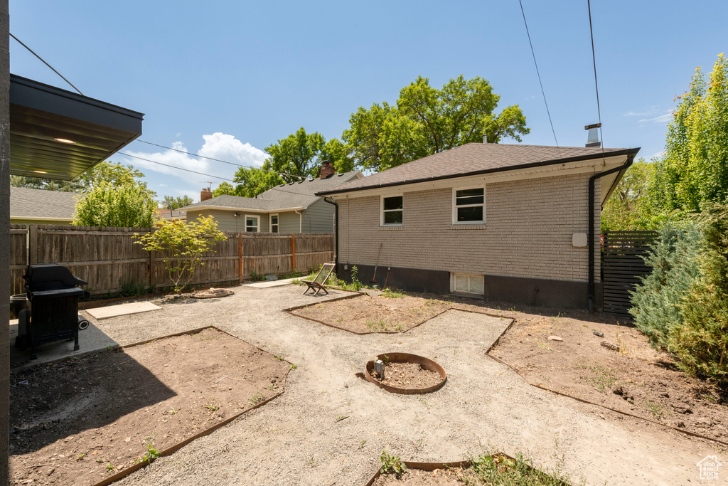 Rear view of property featuring brick siding and a fenced backyard