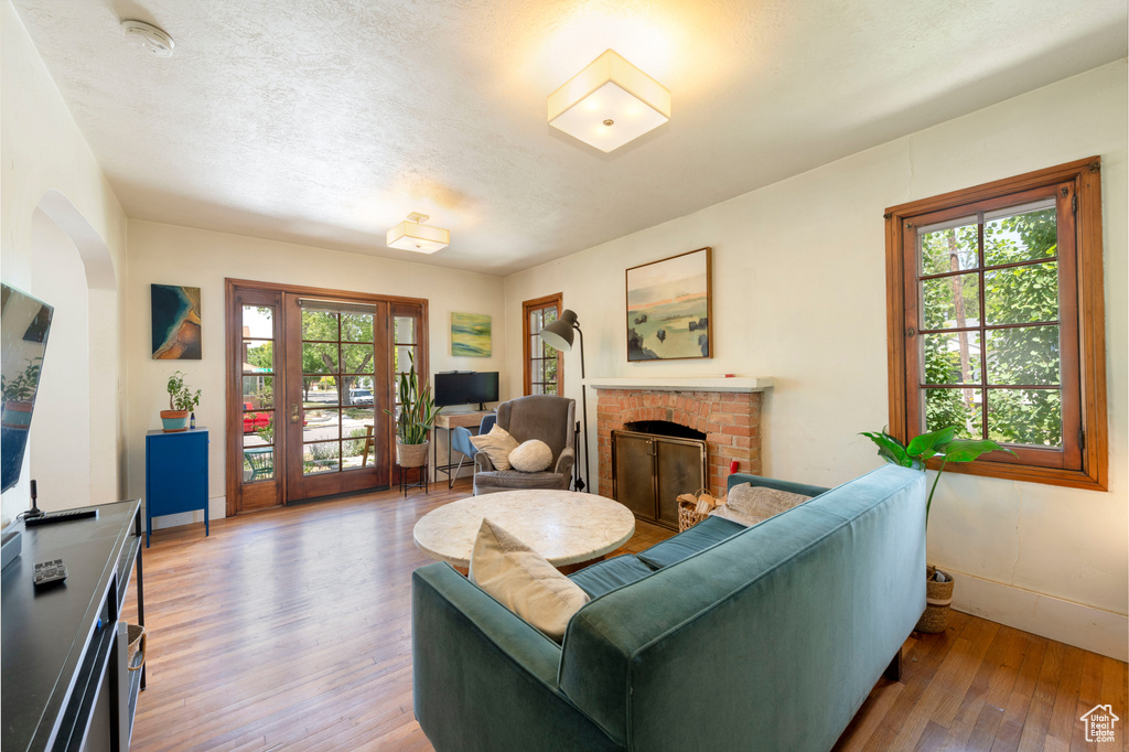 Living room with healthy amount of natural light, wood-type flooring, and a fireplace