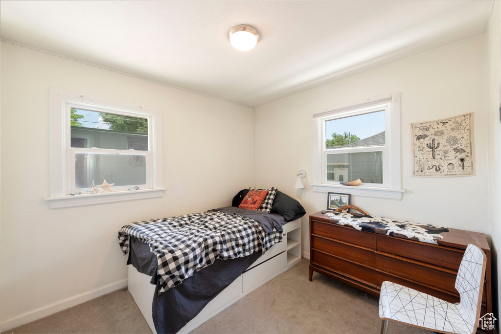 Carpeted bedroom featuring multiple windows