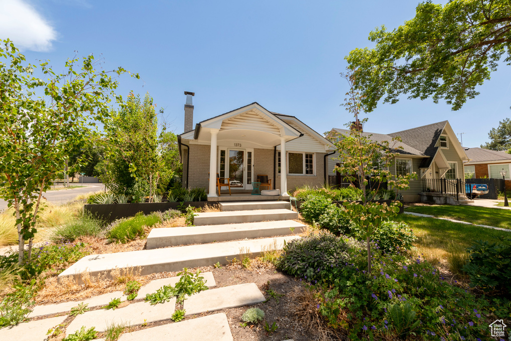 View of front of house with a chimney and brick siding