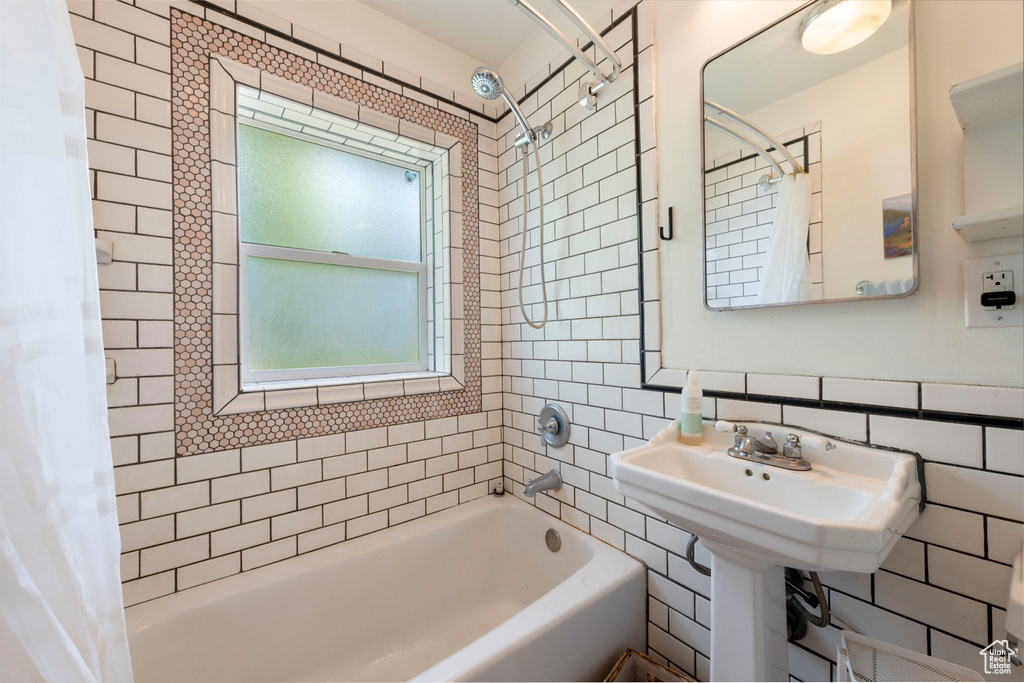 Full bathroom with shower / bath combo with shower curtain and tile walls