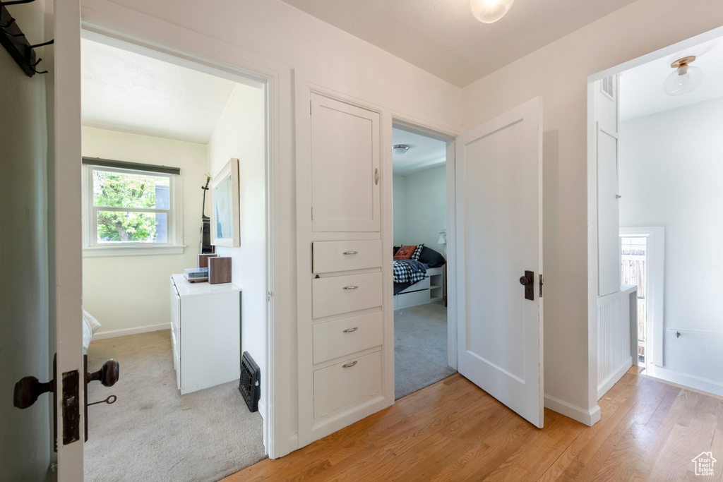Corridor featuring light wood-type flooring and baseboards