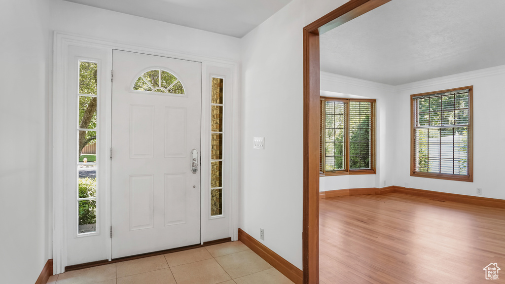 Entrance foyer with baseboards and light tile patterned flooring
