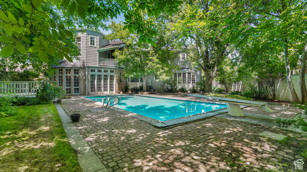 View of swimming pool with french doors and a patio area