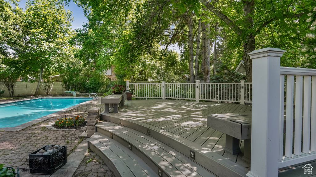 View of swimming pool featuring a wooden deck and a fenced backyard