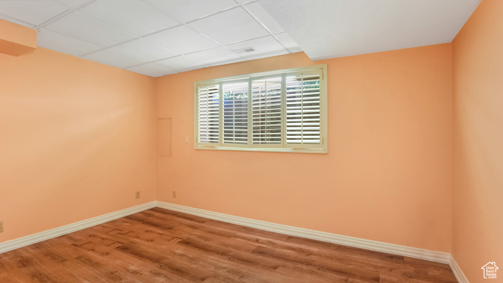 Empty room with a paneled ceiling and wood finished floors
