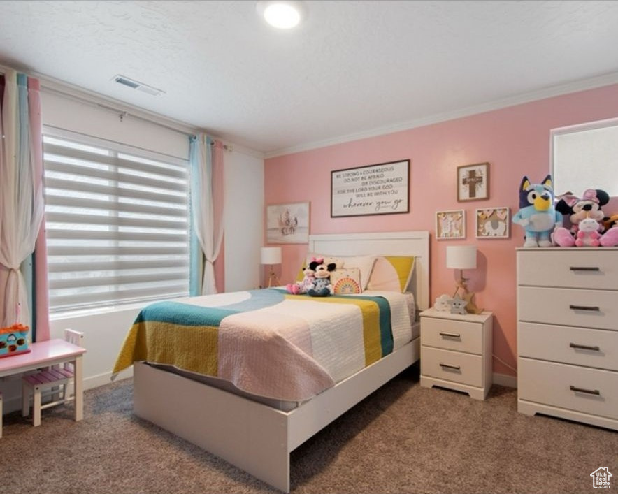 Carpeted bedroom featuring crown molding and baseboards