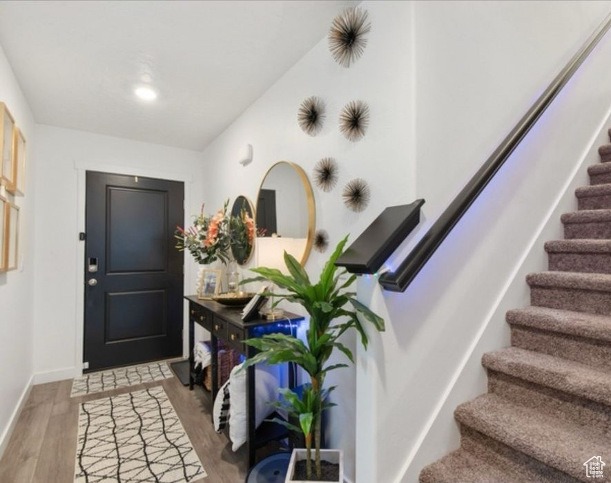 Entrance foyer featuring stairway, light wood-style flooring, and baseboards