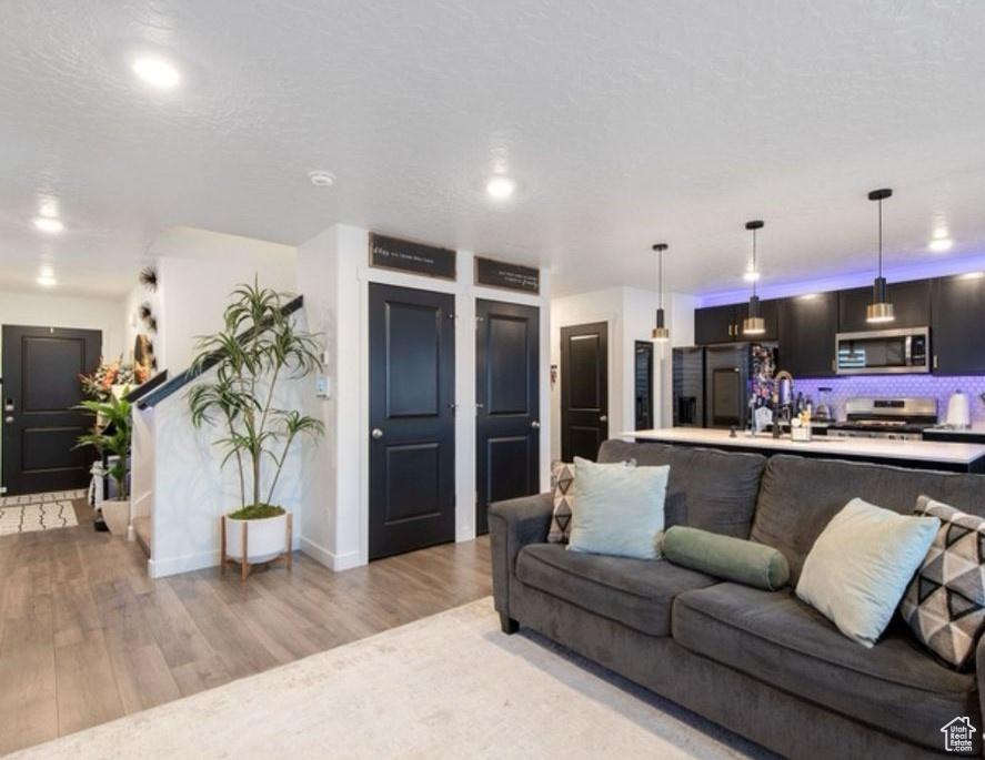 Living room featuring light wood-type flooring, baseboards, and recessed lighting