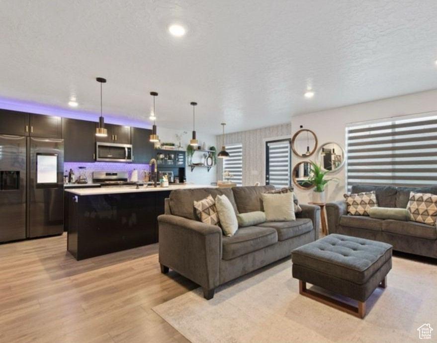 Living area with light wood-style floors and recessed lighting