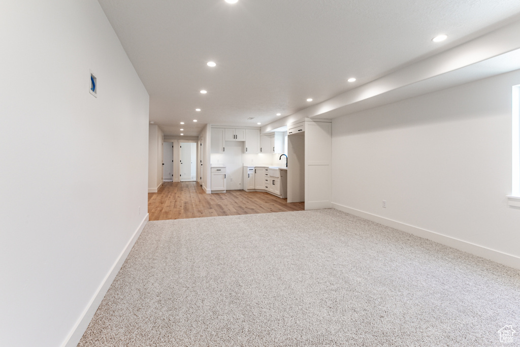 Unfurnished living room with light colored carpet and recessed lighting