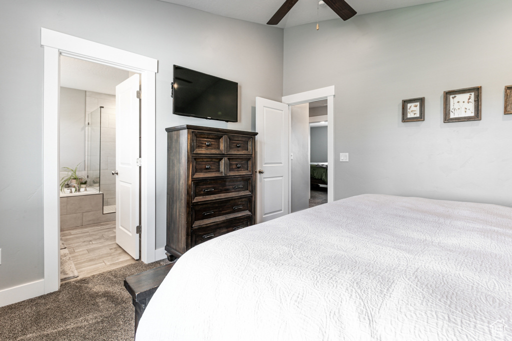 Bedroom with carpet, lofted ceiling, a ceiling fan, and ensuite bath