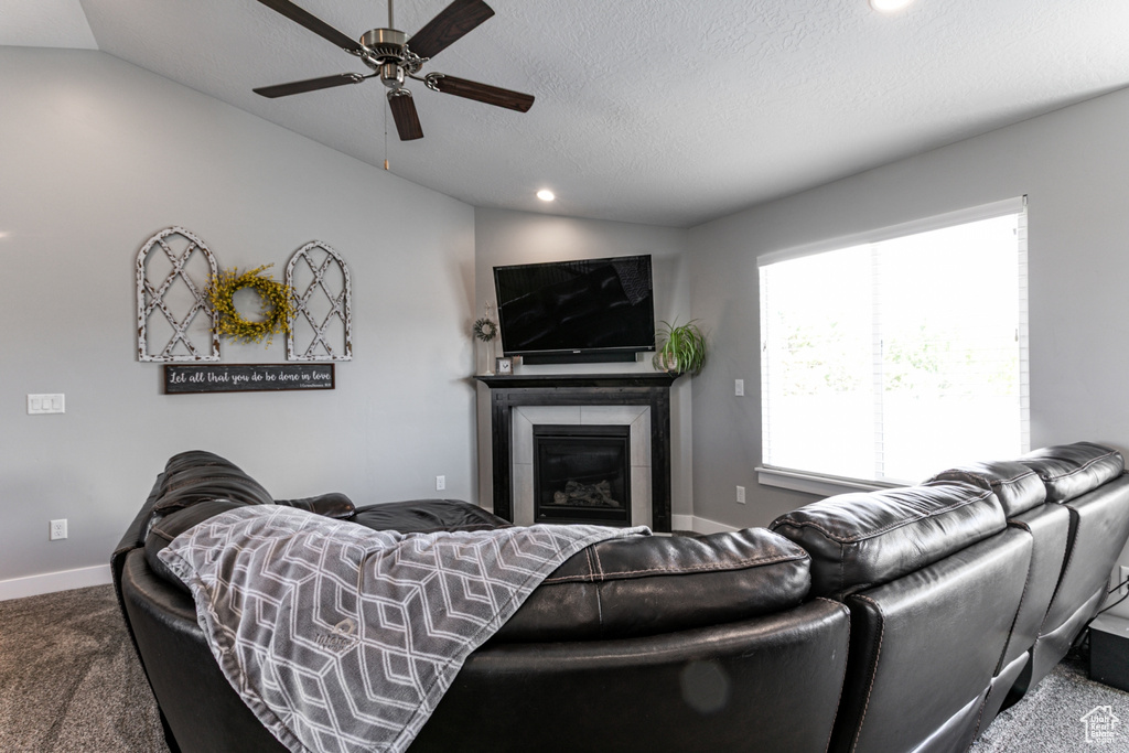 Living area featuring vaulted ceiling, carpet, ceiling fan, a glass covered fireplace, and recessed lighting