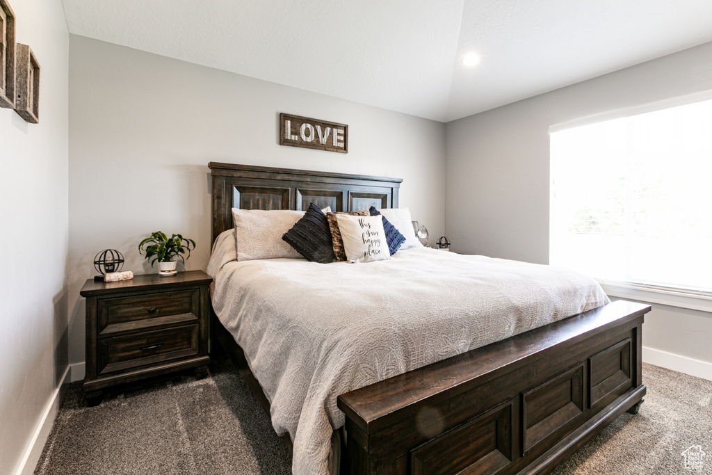 Bedroom with dark colored carpet and baseboards