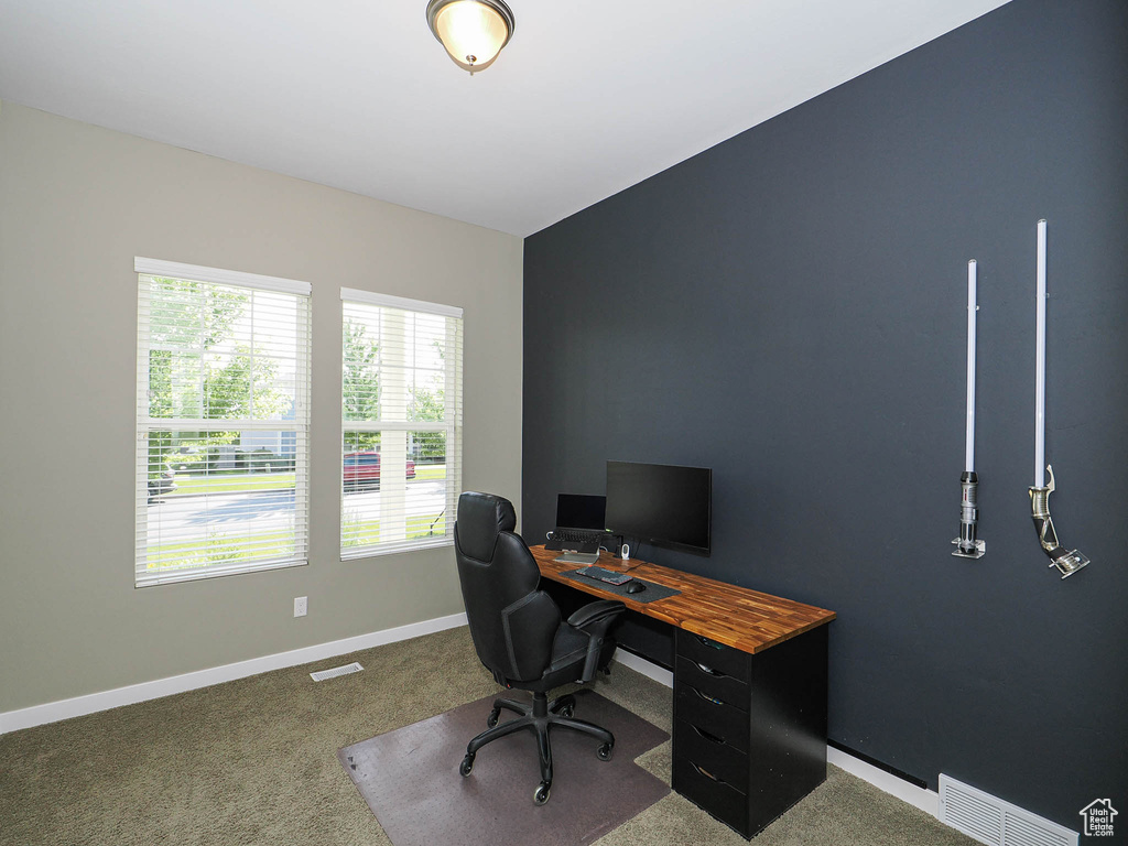 Carpeted home office featuring baseboards