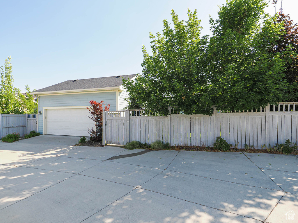 View of side of property featuring driveway and a garage