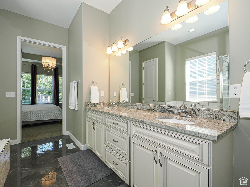 Ensuite bathroom with a chandelier and double vanity