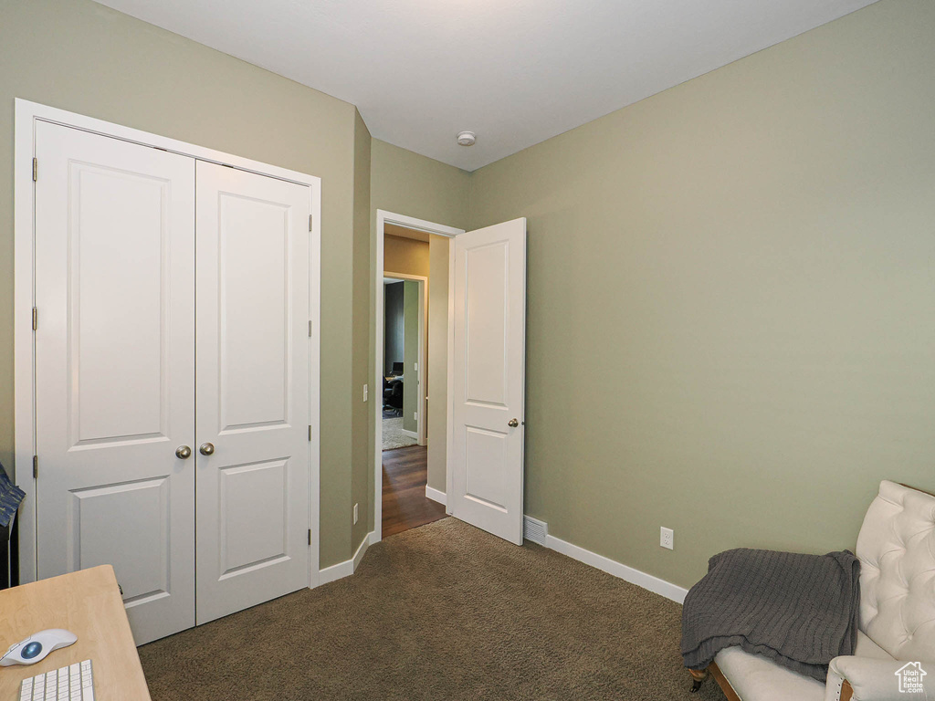 Unfurnished room featuring dark carpet and baseboards