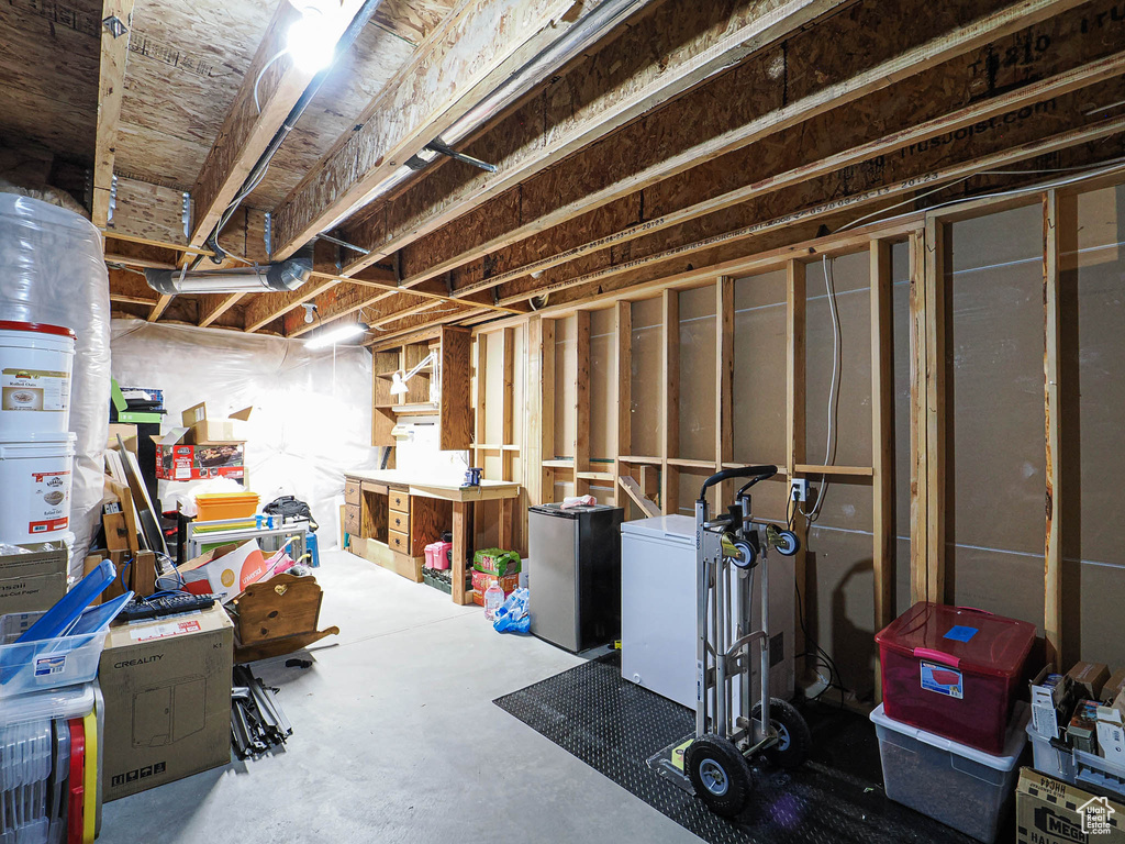 Unfinished below grade area featuring freestanding refrigerator