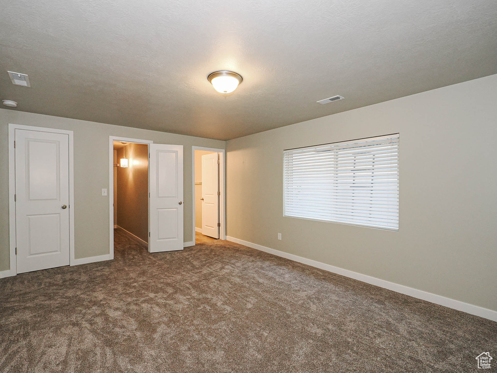 Unfurnished bedroom featuring carpet floors and baseboards