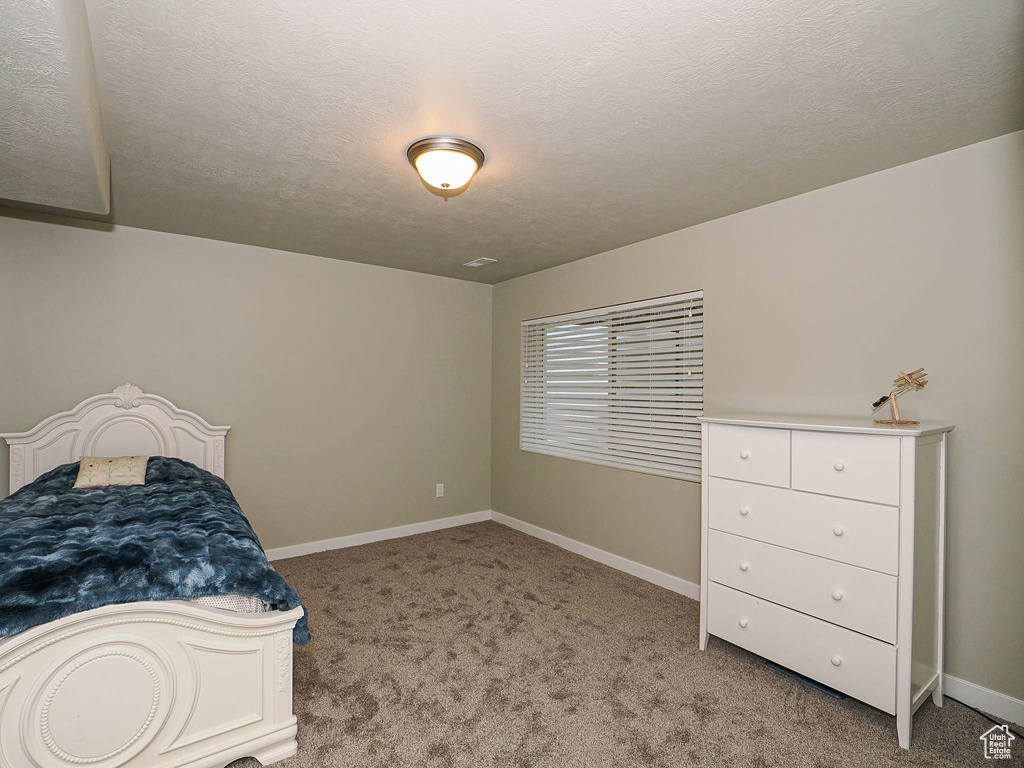 Bedroom with light carpet and a textured ceiling