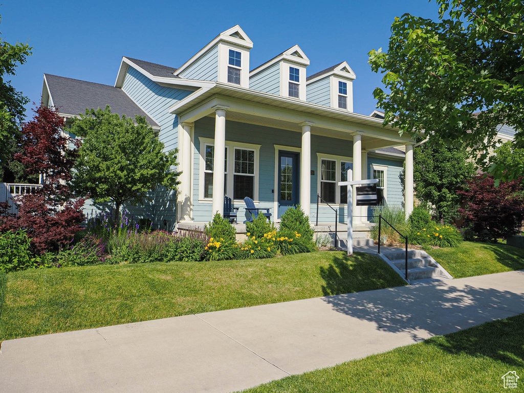 View of front facade with a front yard and covered porch