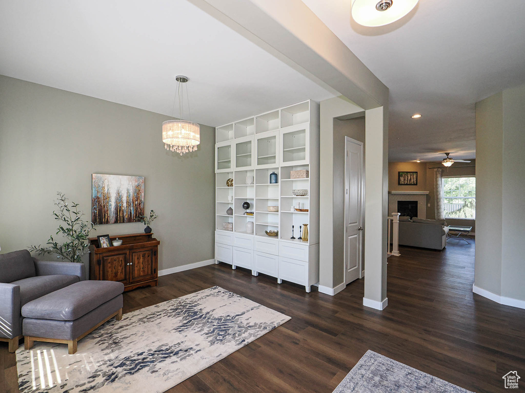 Living area with recessed lighting, a chandelier, dark wood-style floors, a fireplace, and a ceiling fan
