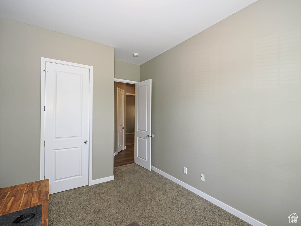 Unfurnished bedroom with carpet flooring and baseboards