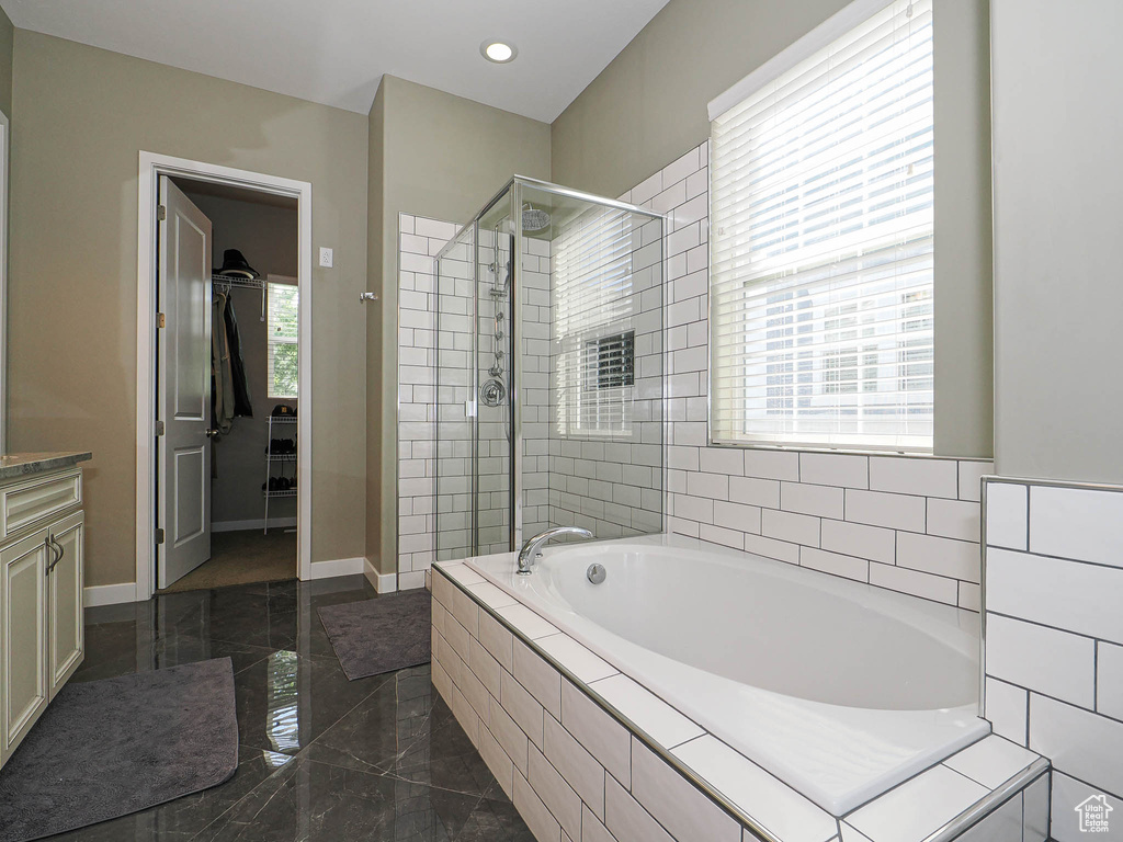 Bathroom featuring a shower stall, a bath, vanity, recessed lighting, and marble tiled flooring