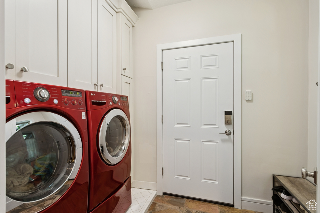Washroom featuring washer and clothes dryer and cabinet space