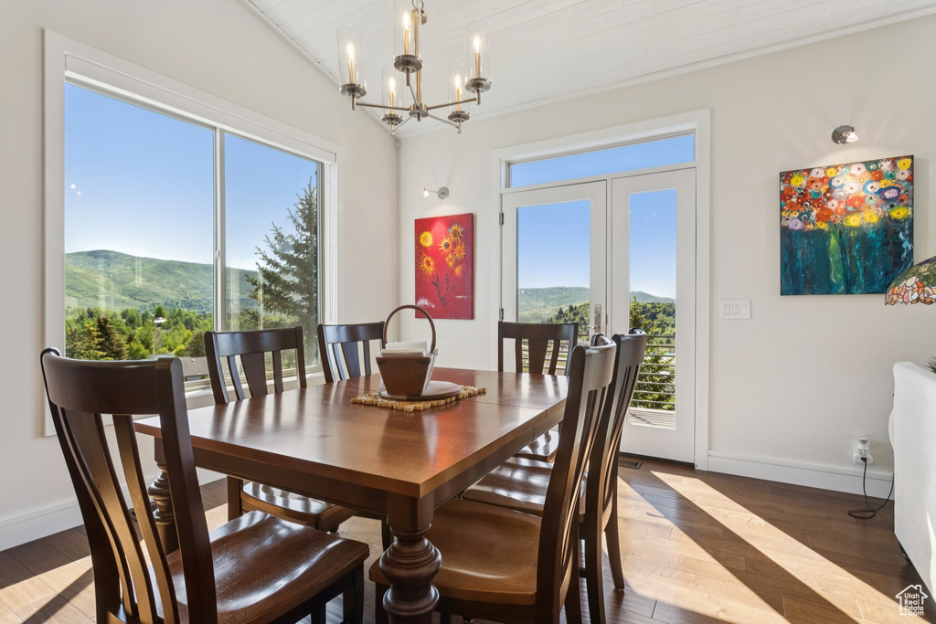 Dining space with a mountain view, wood finished floors, and a chandelier