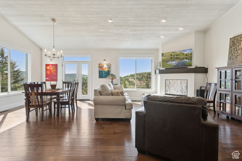 Living area featuring a chandelier, wood ceiling, and dark wood-style flooring