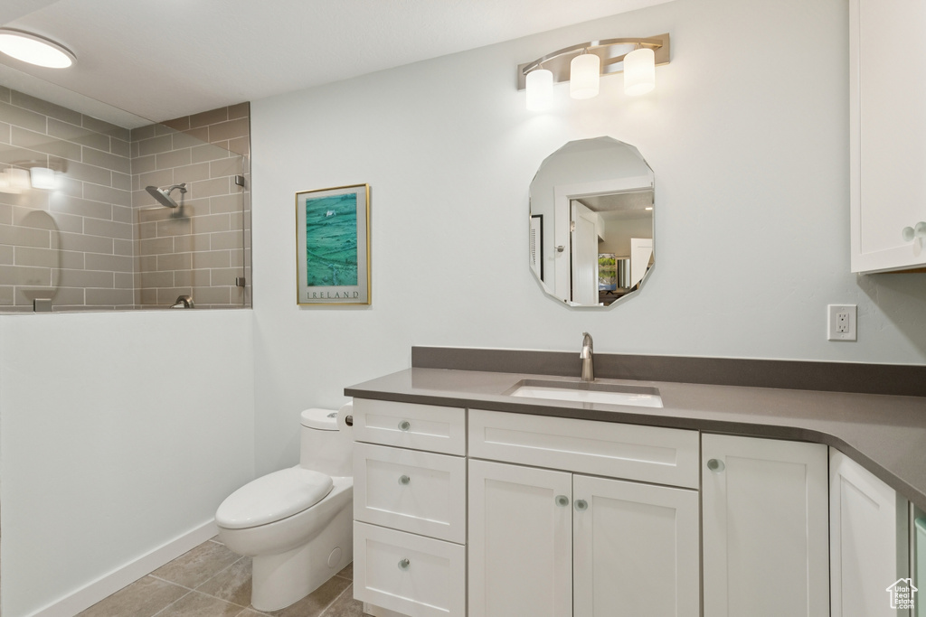 Bathroom with vanity, tiled shower, and tile patterned floors