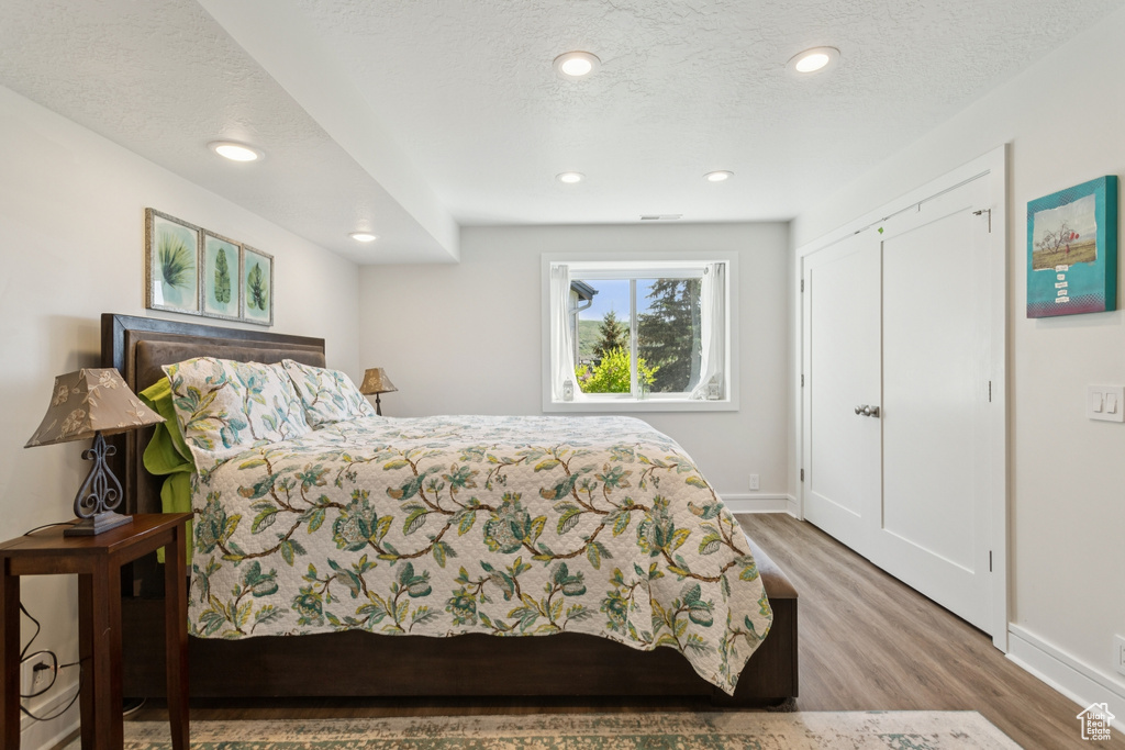 Bedroom with wood finished floors and recessed lighting